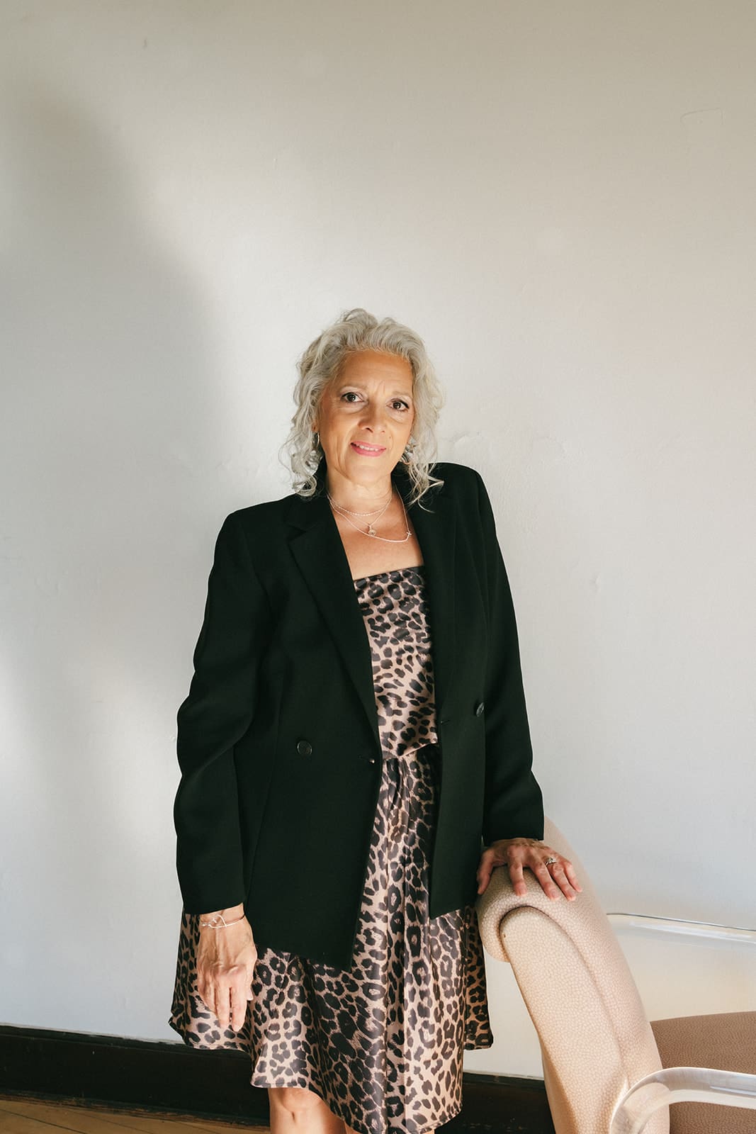 Mom in business clothes leaning on chair