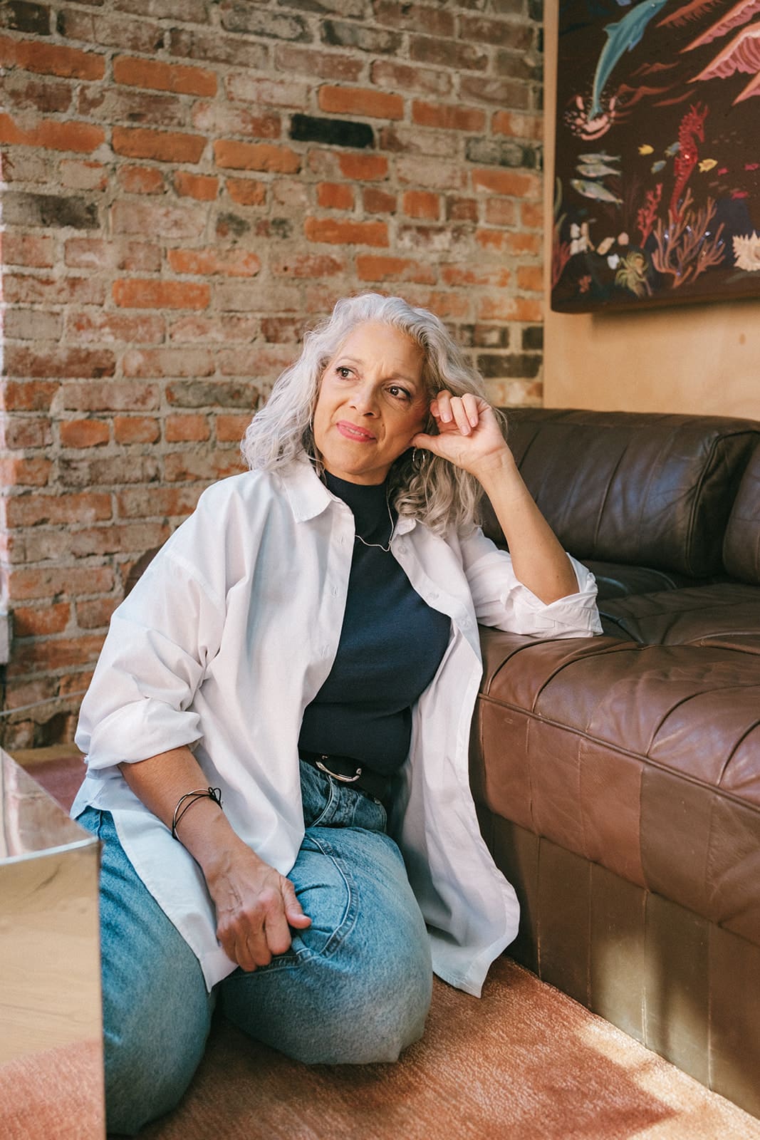 Woman kneeling on floor head resting on hand